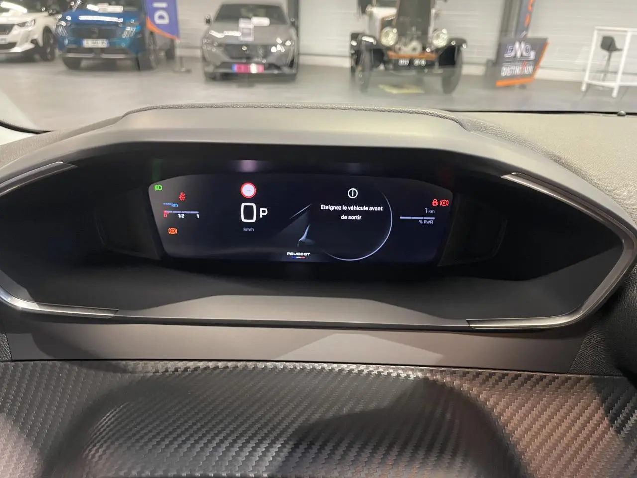 Vue de face du combiné numérique du tableau de bord Peugeot 208 1.2i Hybrid avec décor carbone Slush.