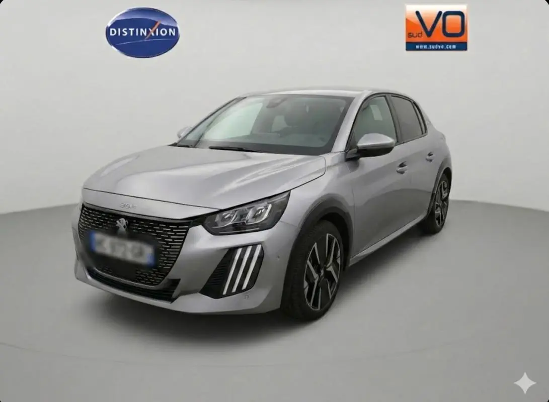 Peugeot 208 Hybrid gris en 3/4 avant droit, avec calandre noire et jantes alliage 17 pouces visibles.