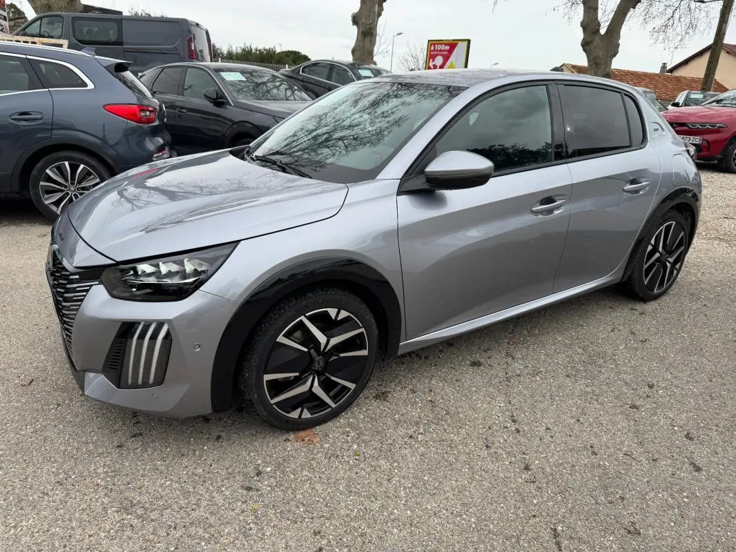 Peugeot 208 Hybrid gris vue 3/4 avant droit, jantes alliage 17 pouces et rétroviseurs dégivrants visibles.
