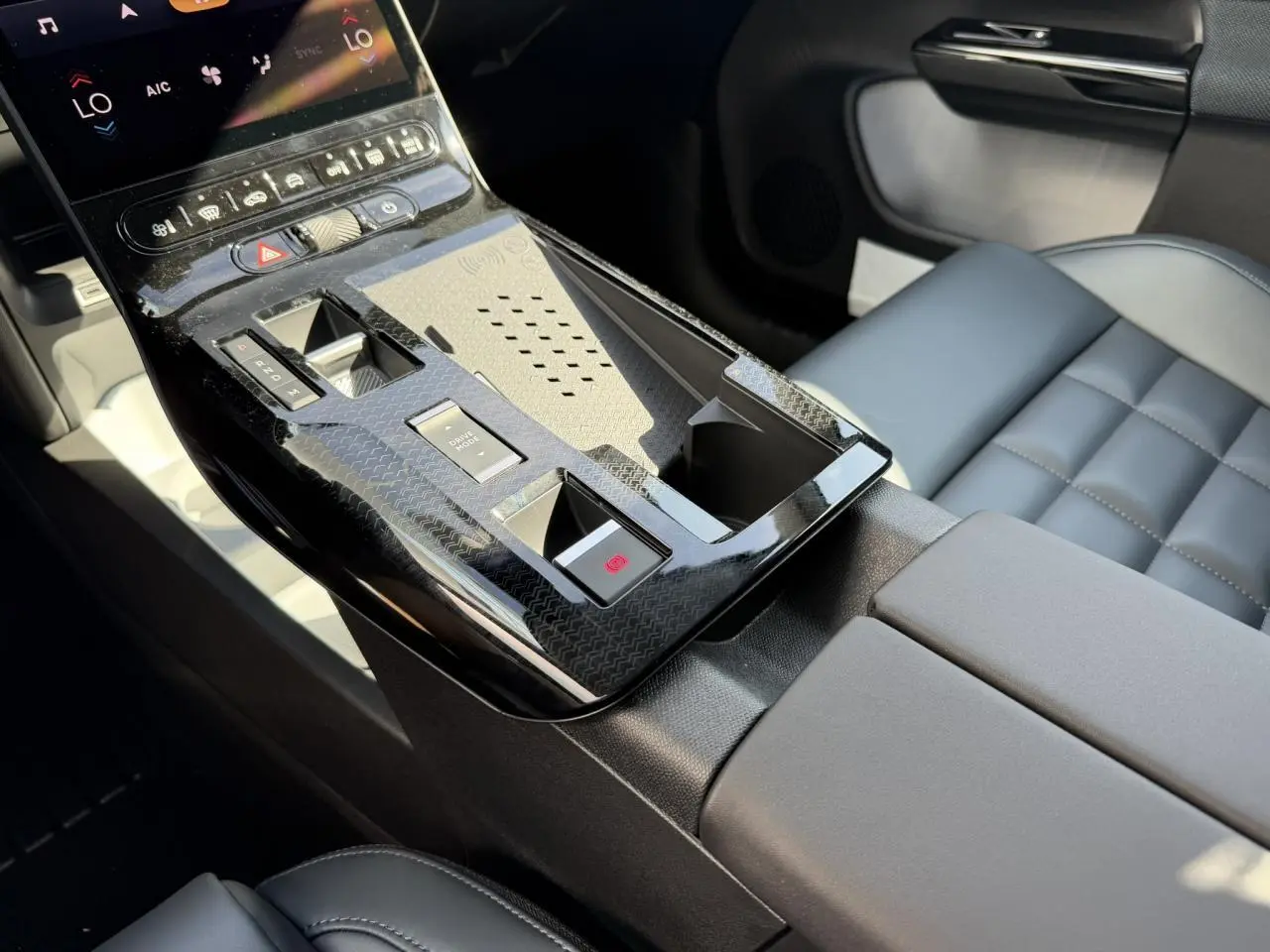 Vue rapprochée de la console centrale noire brillante et des sièges gris du Citroën C5 Aircross hybride 2026.