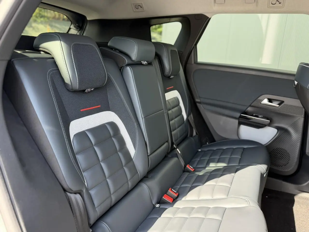 Vue côté droit des sièges arrière en cuir et tissu noir avec surpiqûres blanches du Citroën C5 Aircross 2026.
