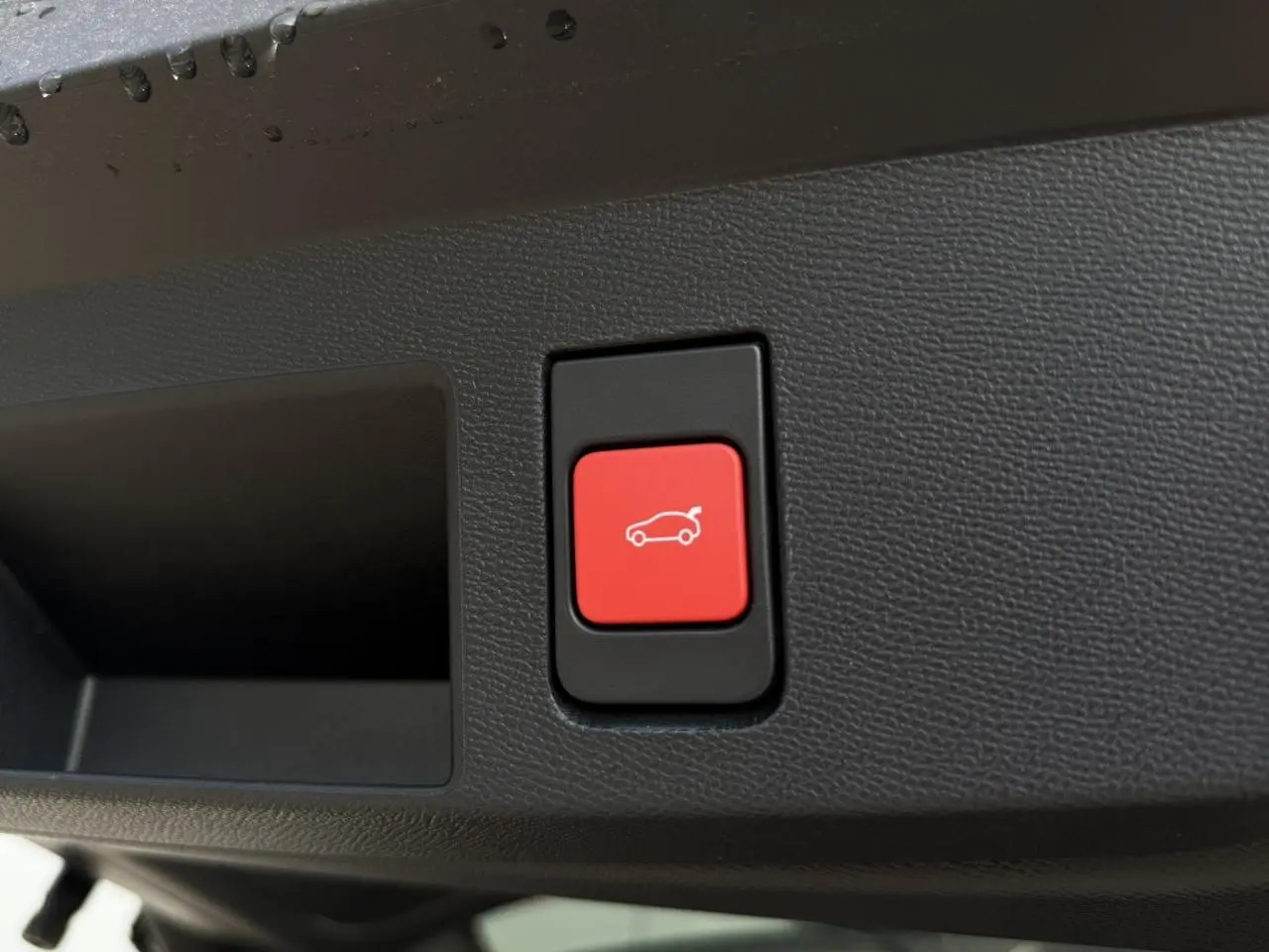 Bouton rouge d'ouverture électrique du hayon sur le panneau intérieur d'un Citroën C5 Aircross 2026.