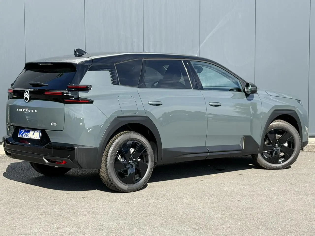 Vue 3/4 arrière droite du Citroën C5 Aircross 2026 vert Astoria avec toit noir et jantes noires brillantes.