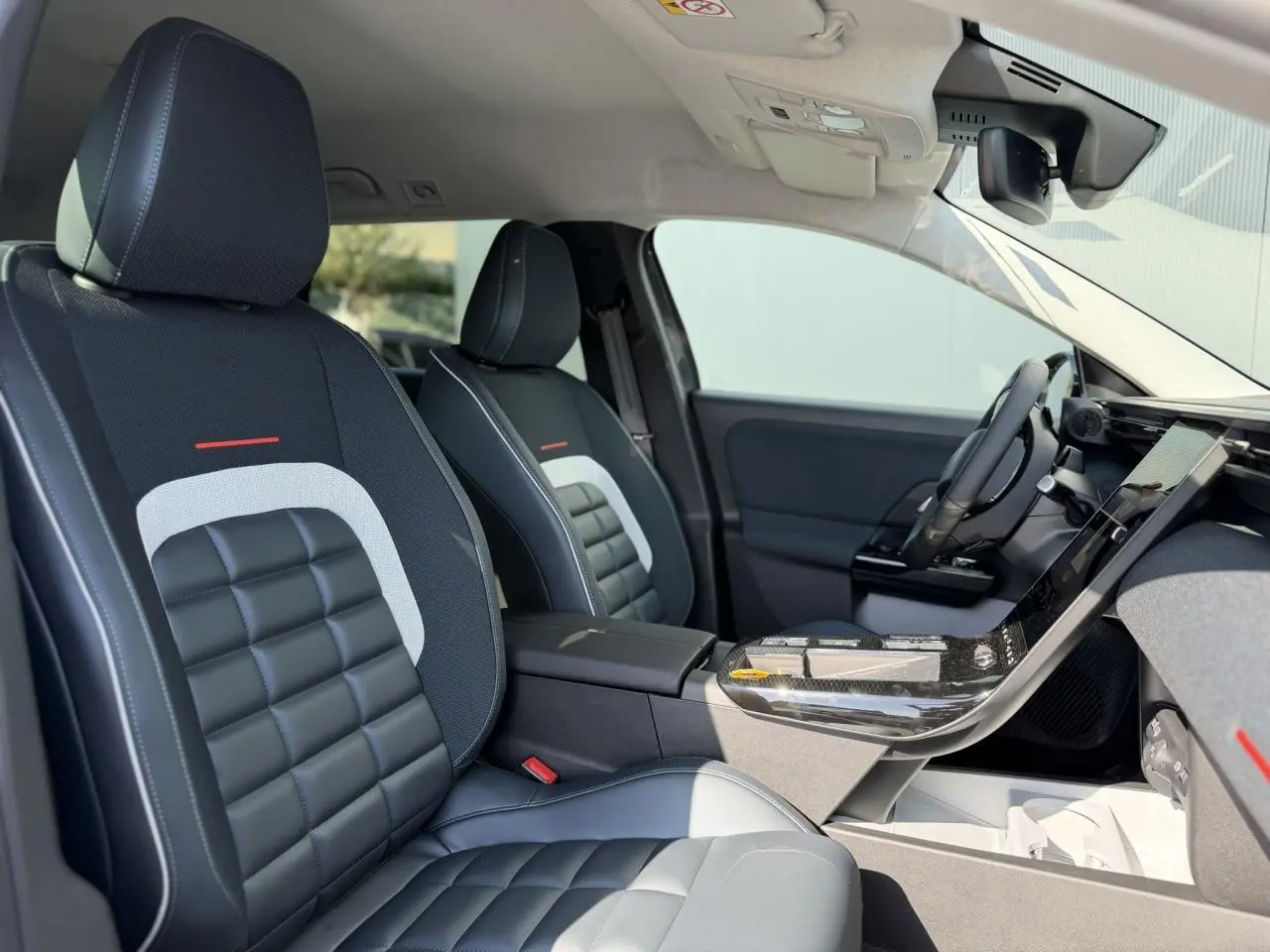 Vue intérieure côté conducteur du Citroën C5 Aircross 2026, sièges noirs avec inserts gris et tableau de bord moderne.