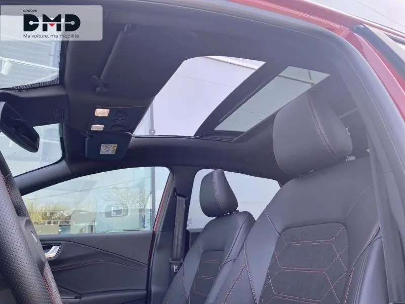 Vue intérieure côté conducteur du Ford Puma rouge avec toit ouvrant panoramique et sièges sport noirs à surpiqûres rouges.