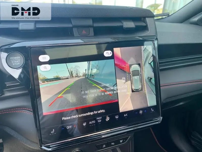 Vue rapprochée de l’écran tactile central du Ford Puma rouge, affichant la caméra de recul et l’aide au stationnement.