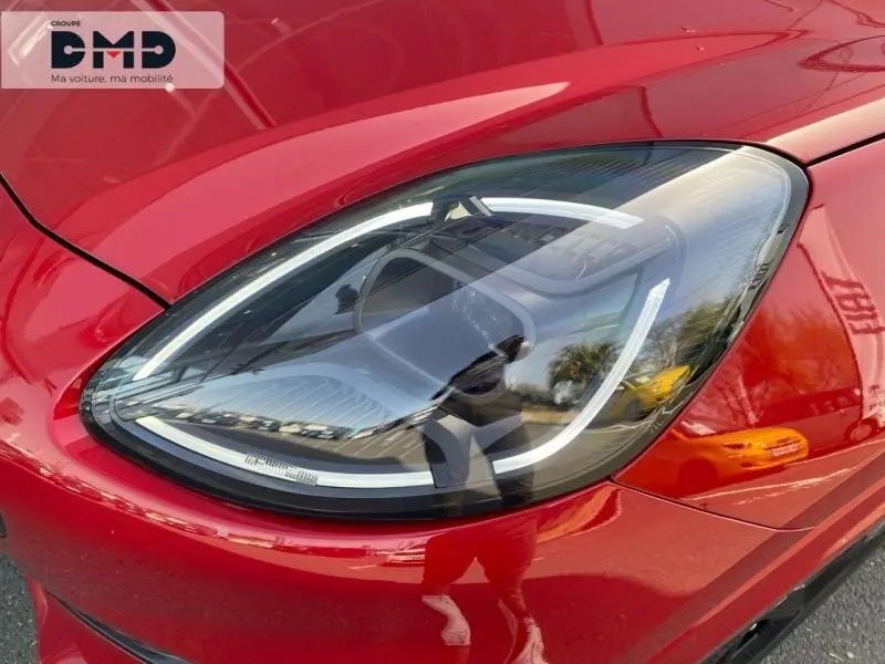Gros plan sur le phare avant droit LED d'une Ford Puma rouge métallisée avec reflets brillants.