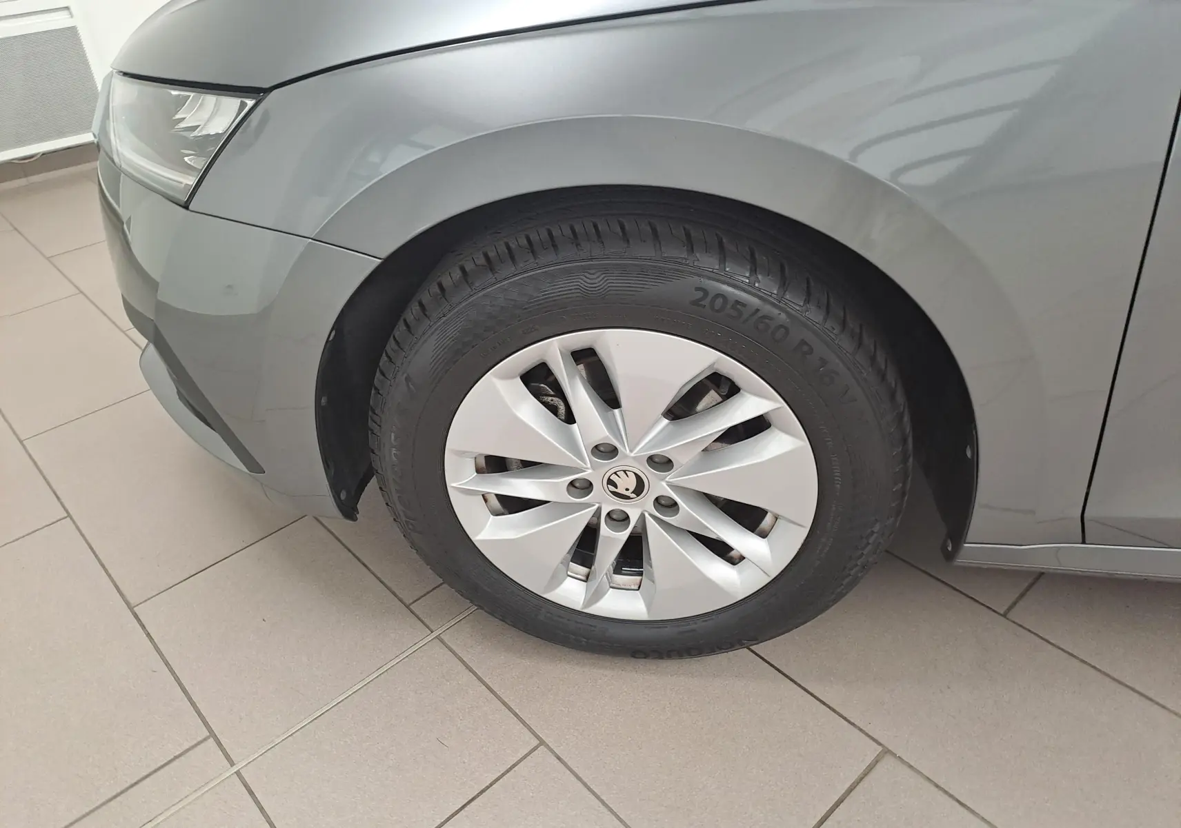Gros plan sur la roue avant gauche et le passage de roue d'une Skoda Octavia Combi 2024 gris graphite métallisé.