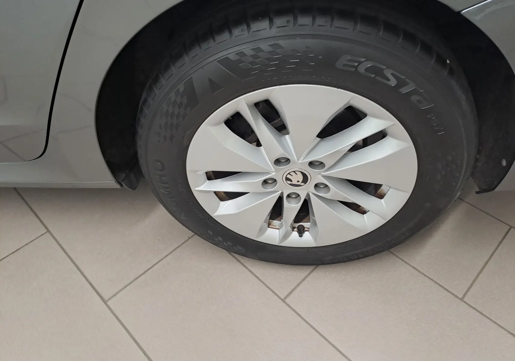 Gros plan sur la roue avant gauche de la Skoda Octavia Combi 2024 gris graphite avec jante en alliage au design moderne.