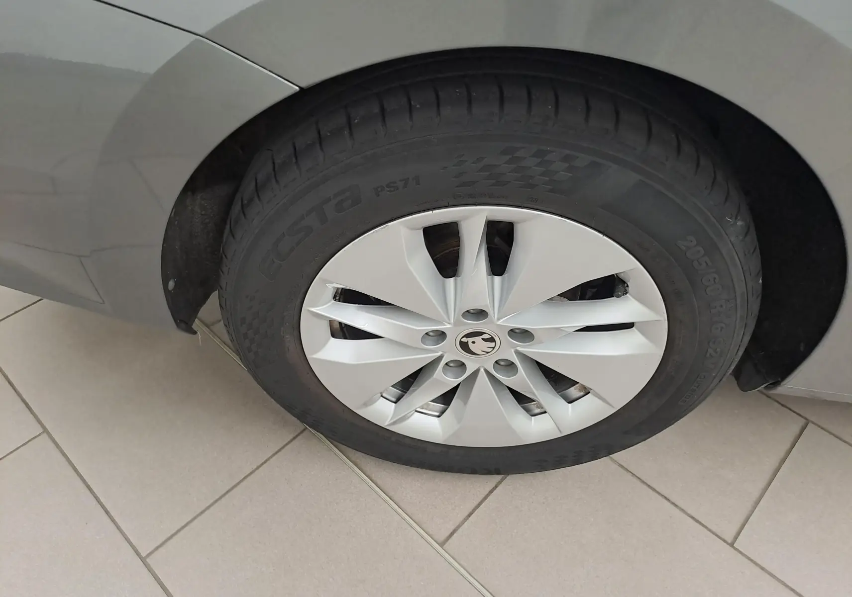 Gros plan sur la roue arrière droite d’une Skoda Octavia Combi 2024 gris graphite avec jante en alliage argenté.