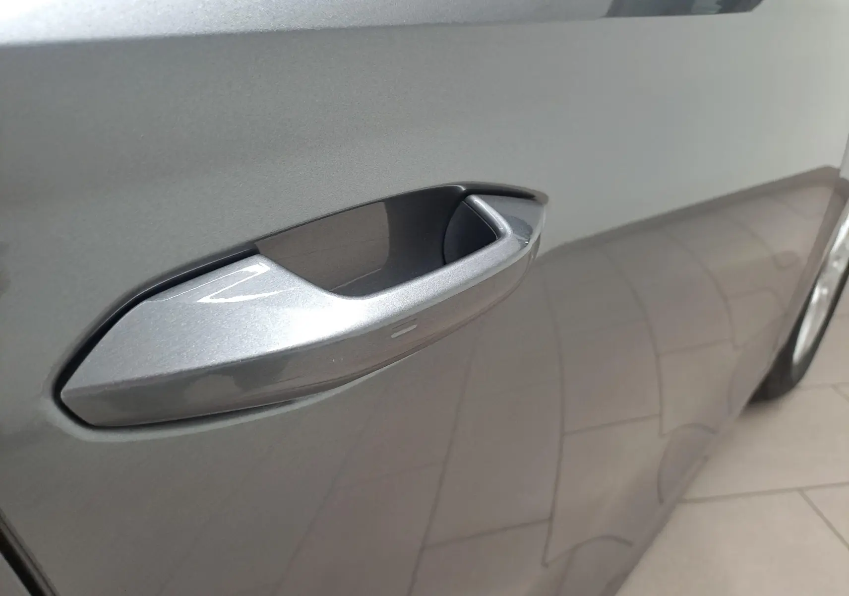 Gros plan sur la poignée de porte côté gauche de la Skoda Octavia Combi 2024 en peinture métallisée gris graphite.