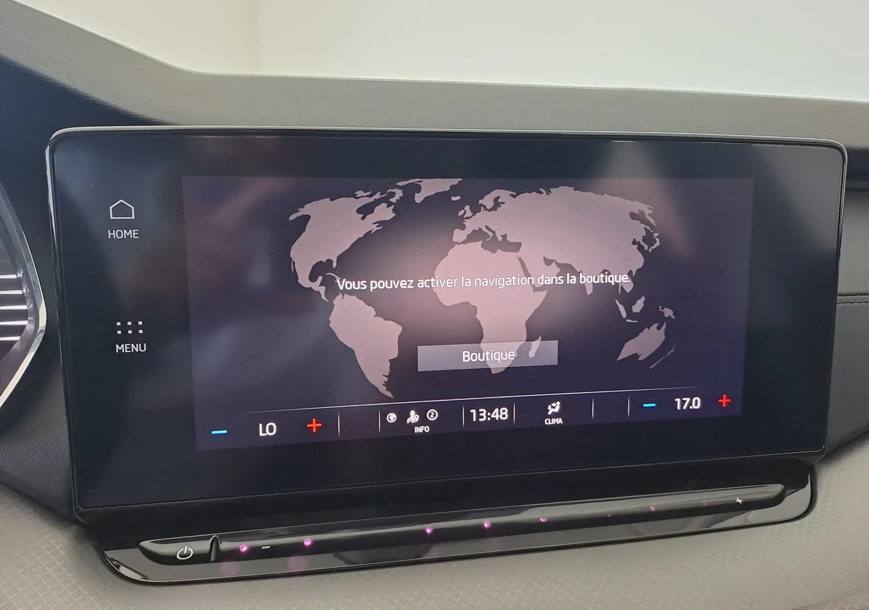 Écran tactile central du tableau de bord de la Skoda Octavia Combi 2024, affichant une carte du monde et les commandes climatiques.