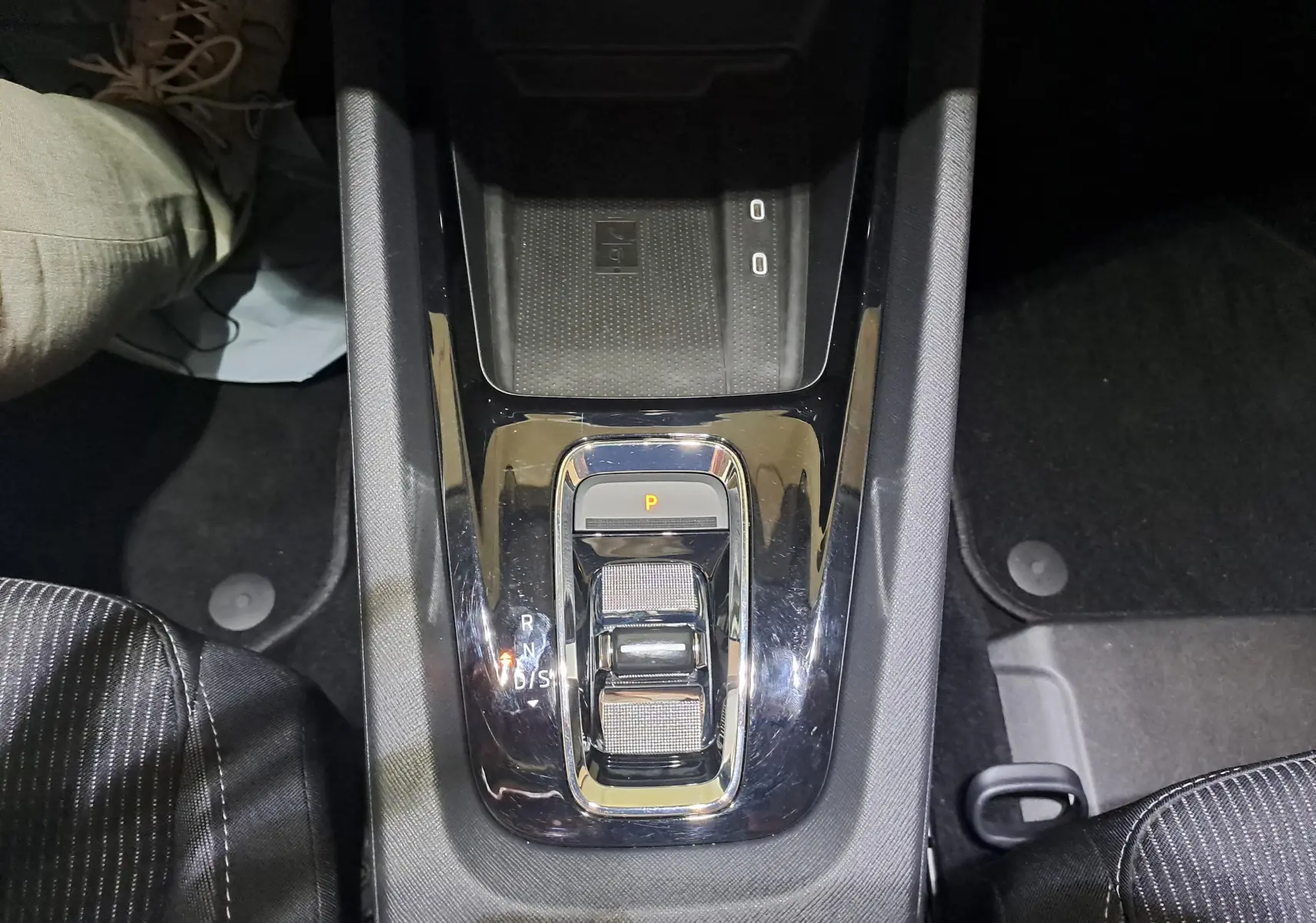 Vue plongeante sur la console centrale noire brillante avec sélecteur de boîte auto et chargeur sans fil d'une Skoda Octavia Combi 2024.