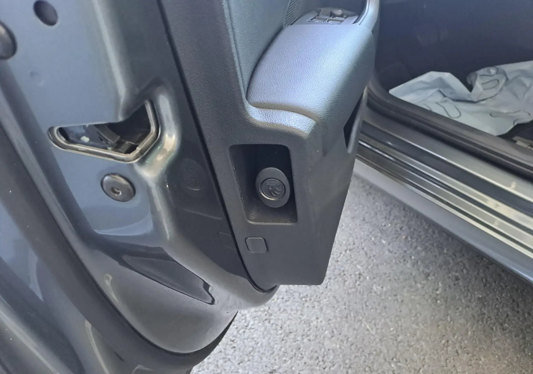 Gros plan sur la charnière de la porte avant gauche d’une Skoda Octavia Combi gris graphite 2024.