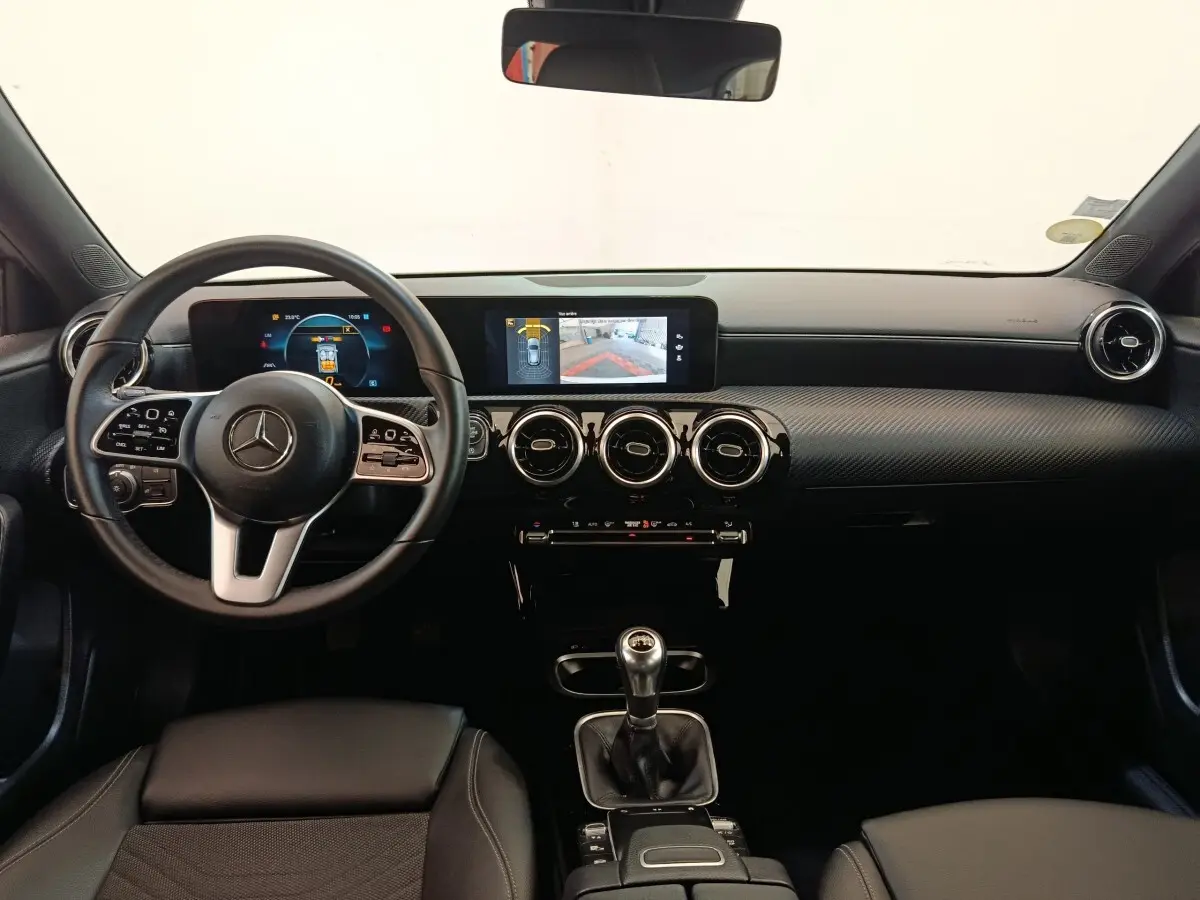 Vue intérieure frontale du tableau de bord noir et volant cuir de la Mercedes Classe A 180 d Business Line 2021.