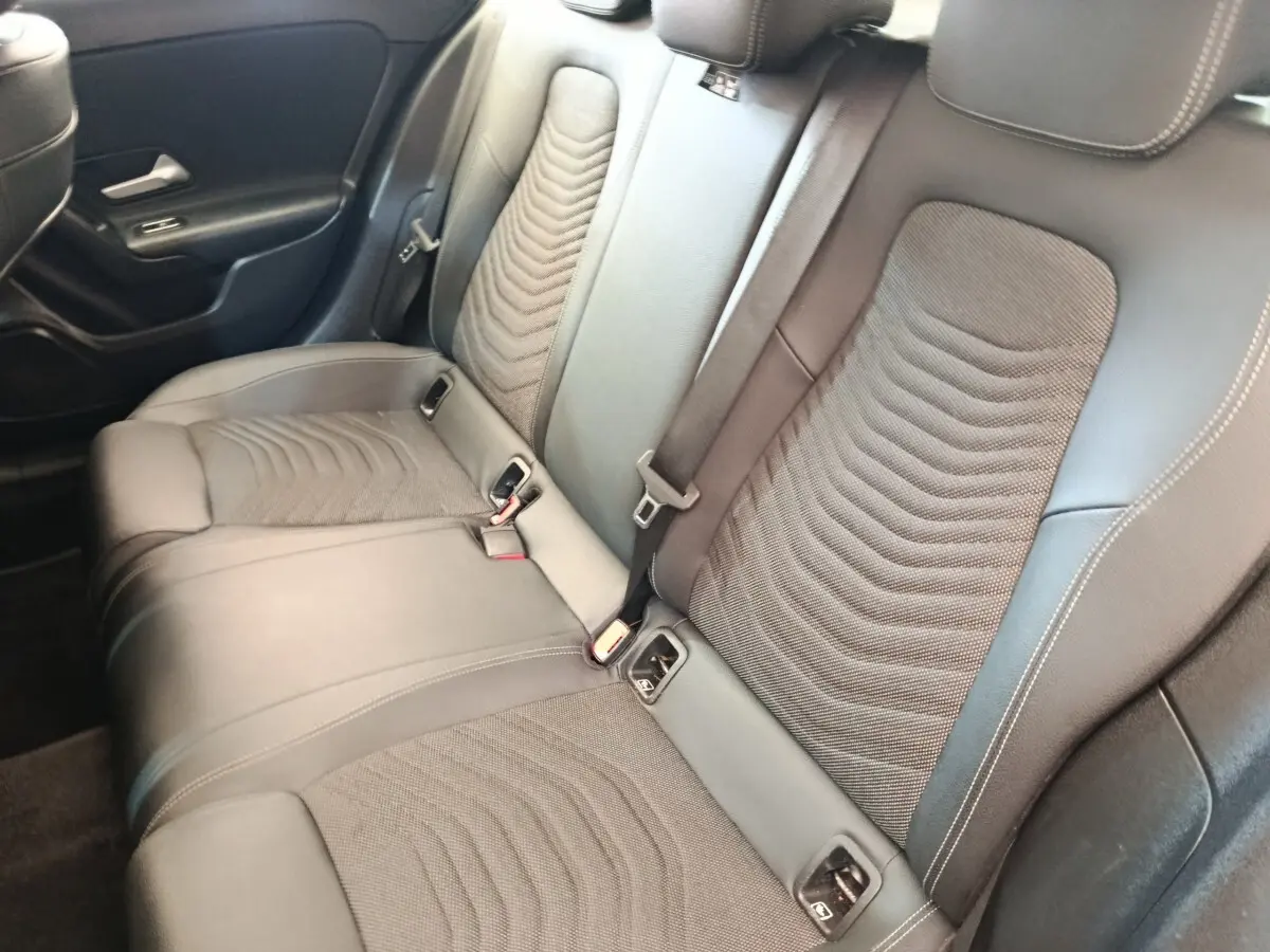 Vue intérieure de la banquette arrière en cuir noir de la Mercedes Classe A 180 d Business Line, côté droit.
