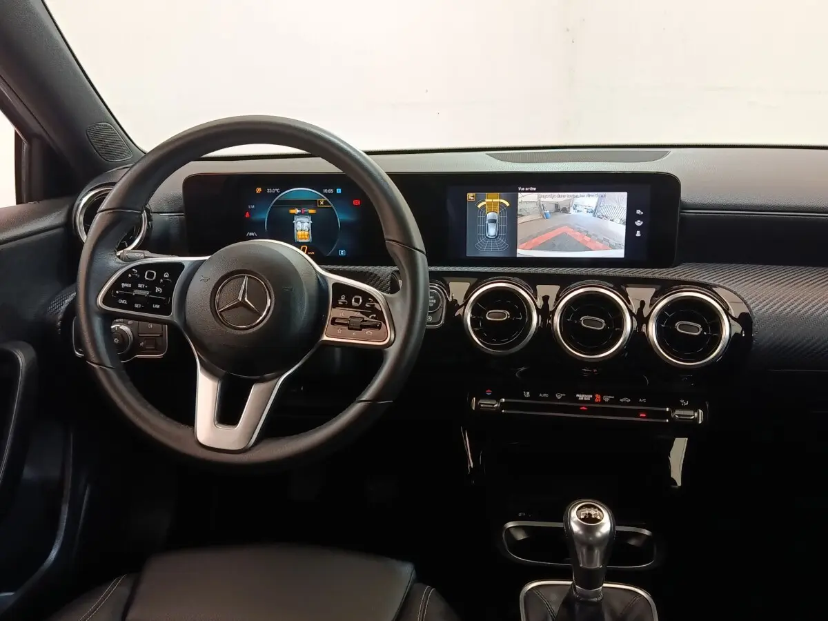 Vue intérieure frontale du tableau de bord noir et volant cuir de la Mercedes Classe A 180 d Business Line 2021.