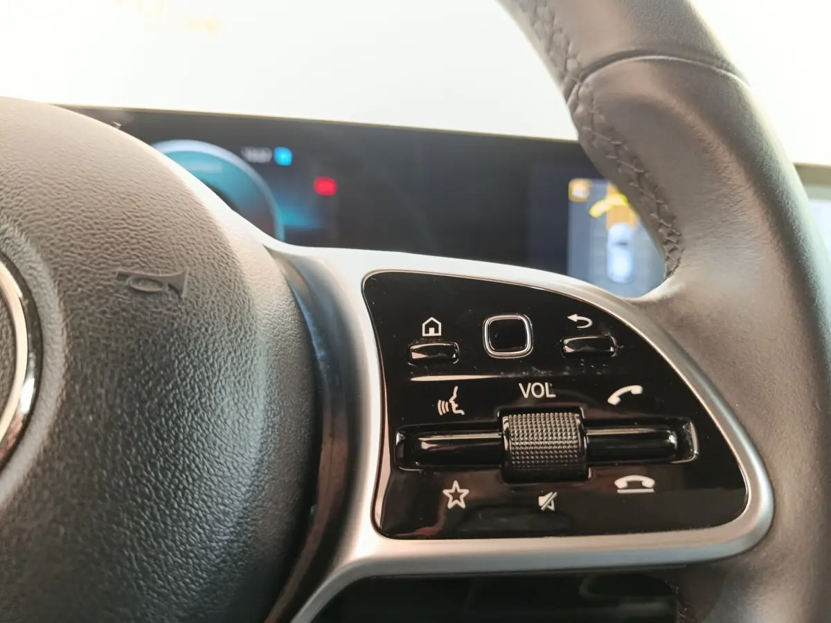 Gros plan sur le volant cuir multifonctions de la Mercedes Classe A 180 d Business Line, avec commandes de volume visibles.