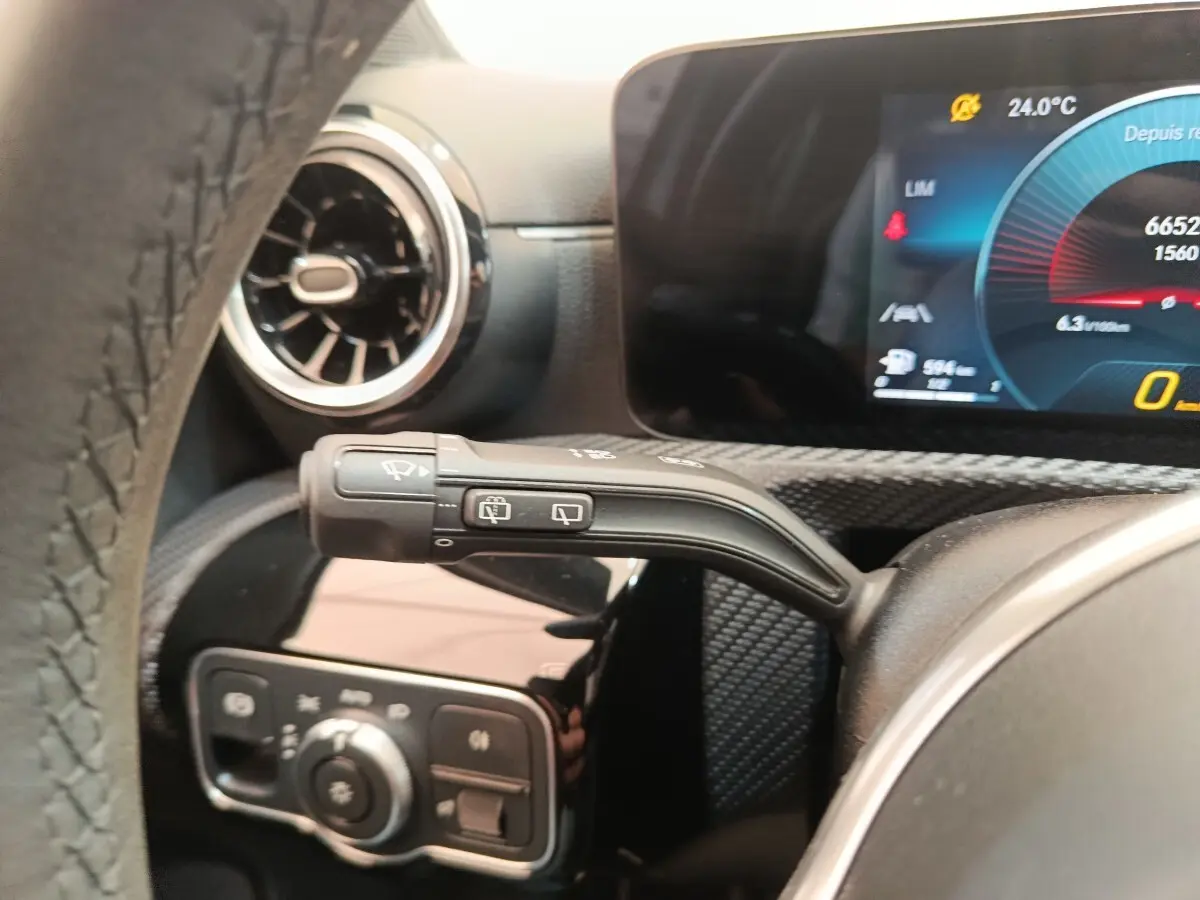 Gros plan sur la manette d’essuie-glace à gauche du volant dans l’habitacle d’une Mercedes Classe A gris clair 2021.