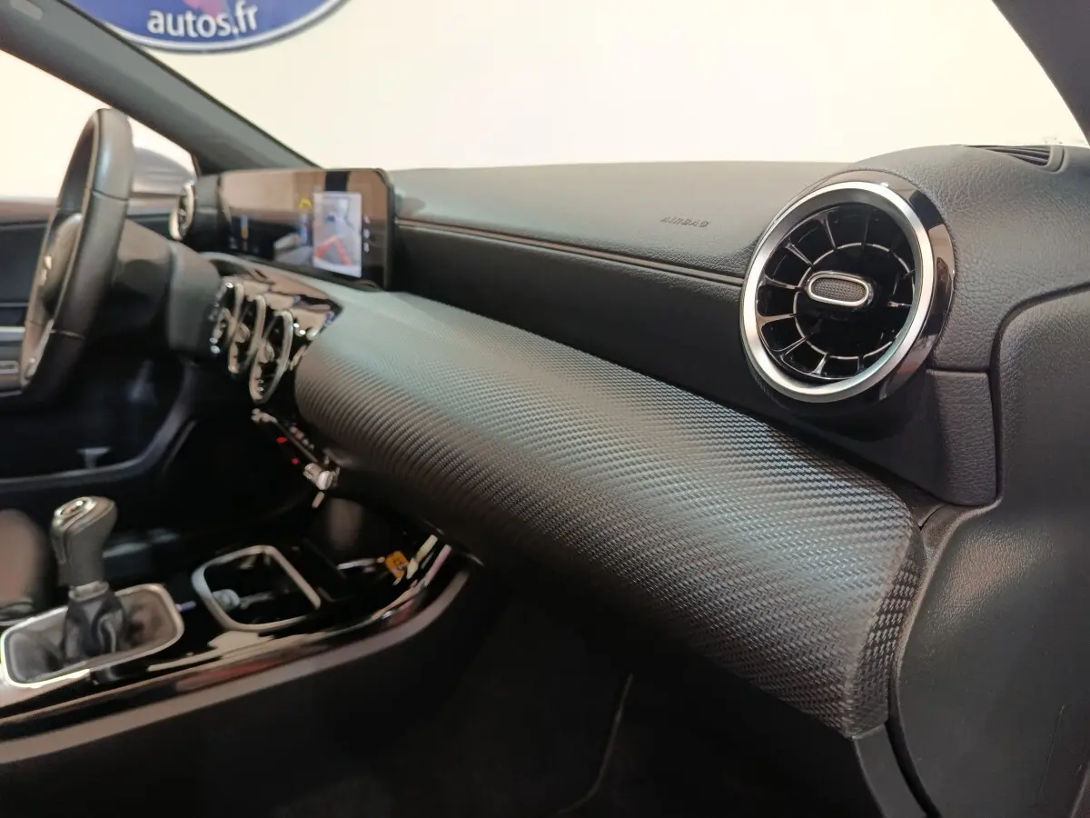 Vue intérieure côté passager du tableau de bord noir texturé et volant cuir de la Mercedes Classe A 180 d Business Line 2021.