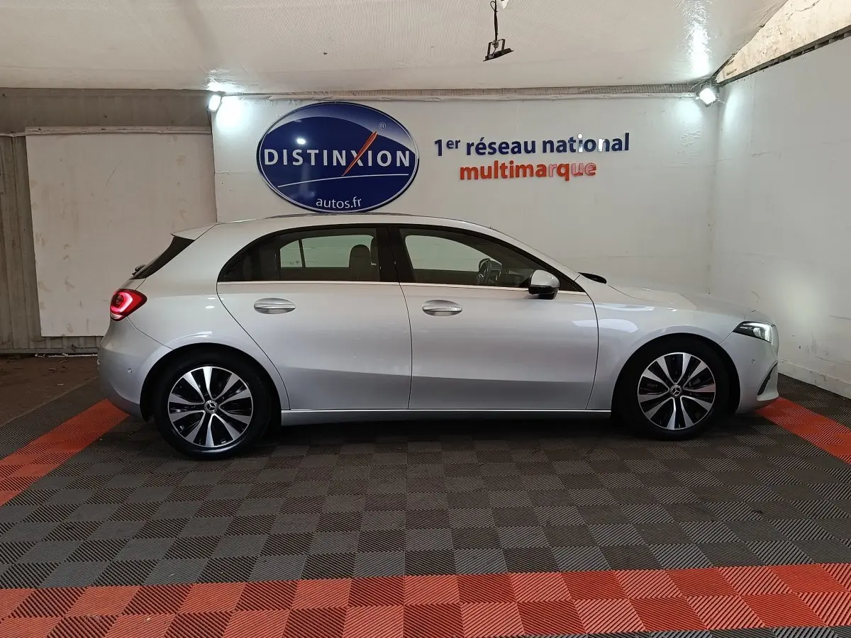 Vue latérale droite d'une Mercedes Classe A gris clair garée en intérieur avec jantes alliage bicolores.