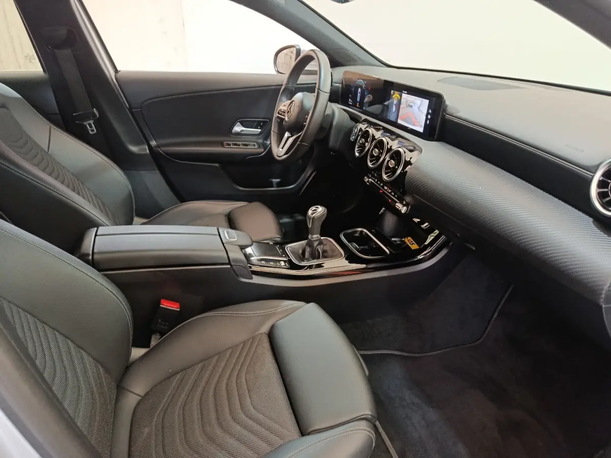 Intérieur noir de la Mercedes Classe A 180 d Business Line 2021, vue côté conducteur avec tableau de bord digital et boîte manuelle.
