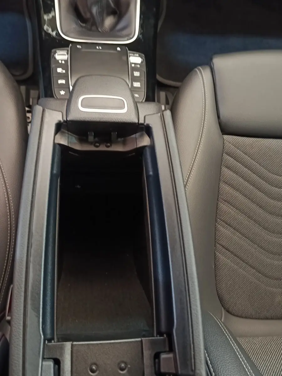 Vue plongeante sur la console centrale ouverte et les sièges gris cuir de la Mercedes Classe A 180 d Business Line 2021.