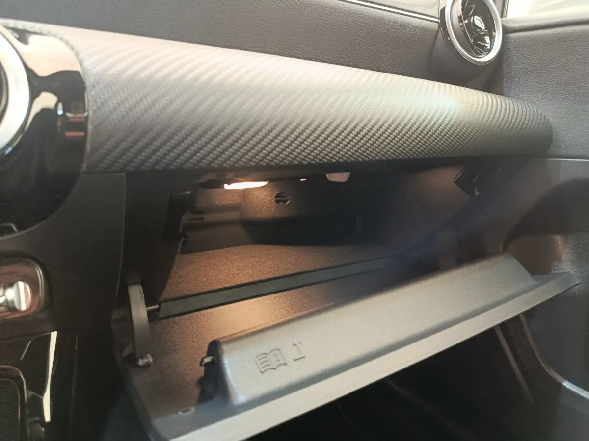 Vue intérieure du vide-poche ouvert côté passager d'une Mercedes Classe A 180 d Business Line 2021 gris clair.