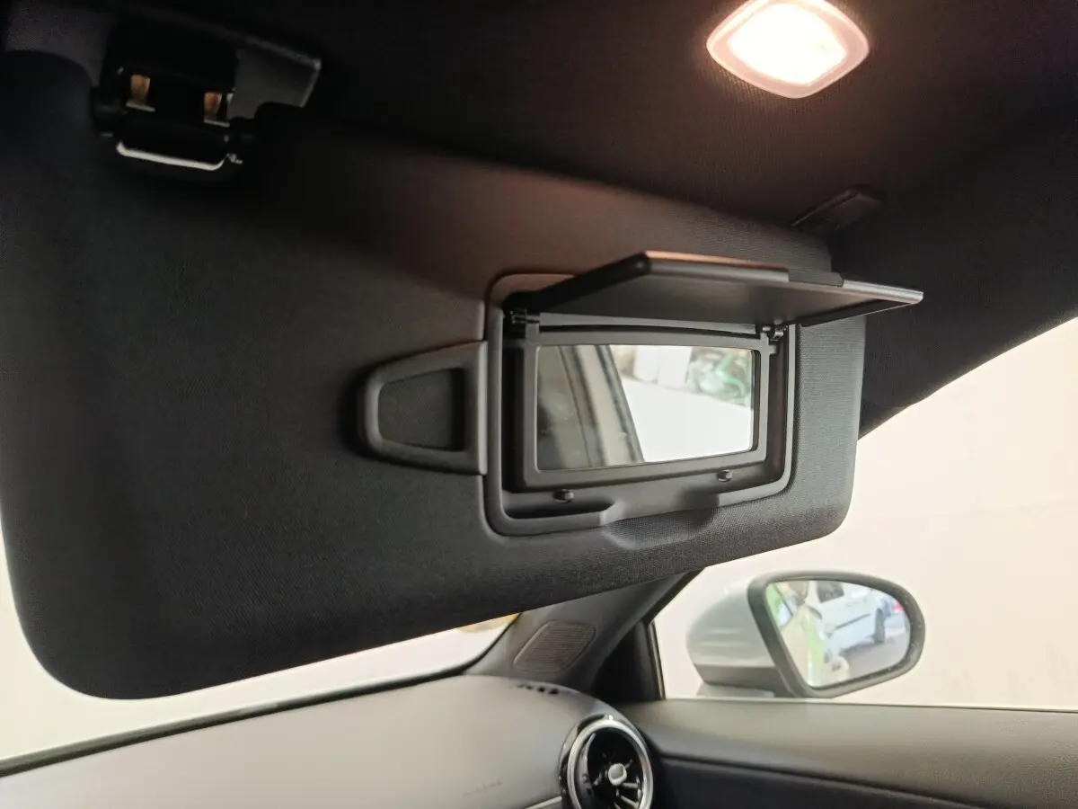Détail du pare-soleil côté conducteur avec miroir éclairé dans l'habitacle gris clair d'une Mercedes Classe A 180 d Business Line 2021.
