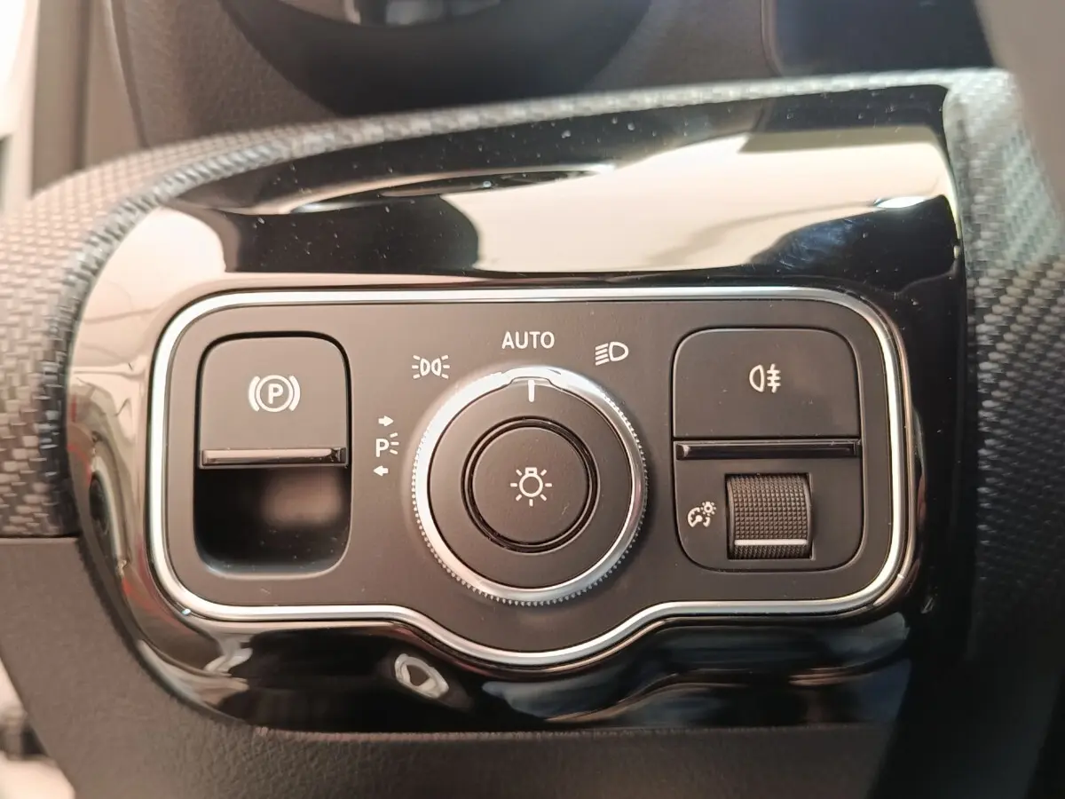 Gros plan sur le panneau de commandes d’éclairage noir brillant de la Mercedes Classe A 180 d Business Line 2021.