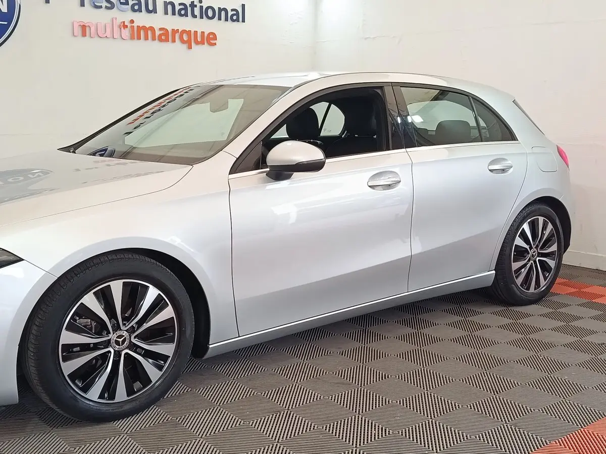 Vue latérale droite d'une Mercedes Classe A 180 d Business Line gris clair avec jantes alliage bicolores.
