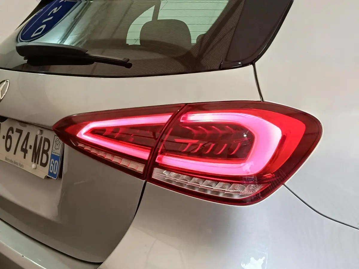 Gros plan sur le feu arrière droit allumé d'une Mercedes Classe A 180 d Business Line gris clair.