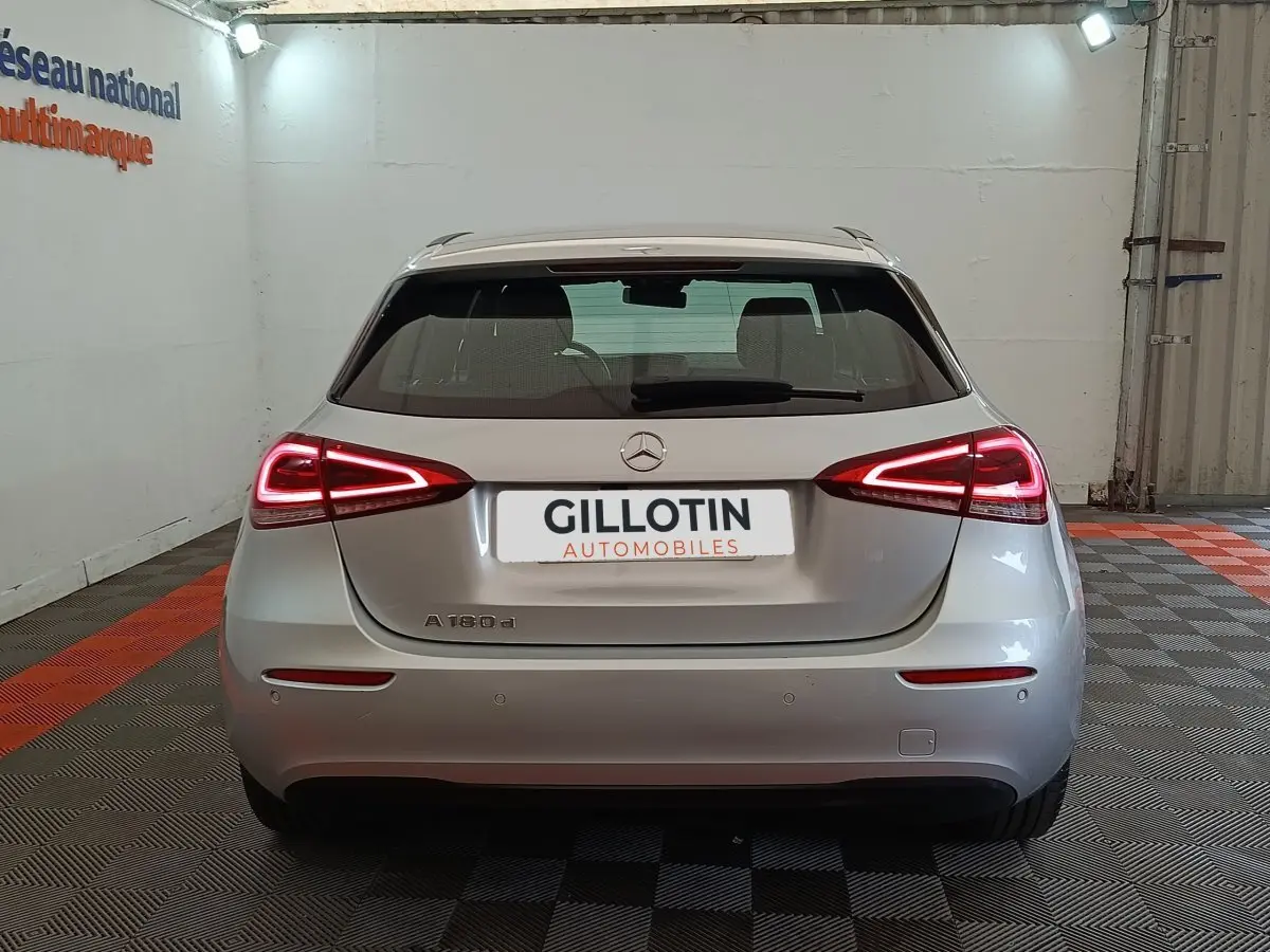 Vue arrière d'une Mercedes Classe A 180 d Business Line gris clair avec feux LED allumés dans un garage.