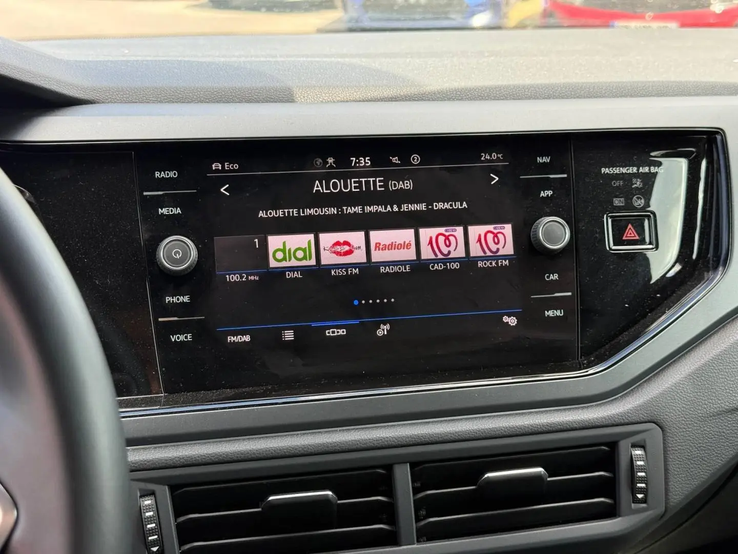 Vue rapprochée de l’écran tactile central du Volkswagen Taigo 2025 avec interface radio DAB et commandes autour.