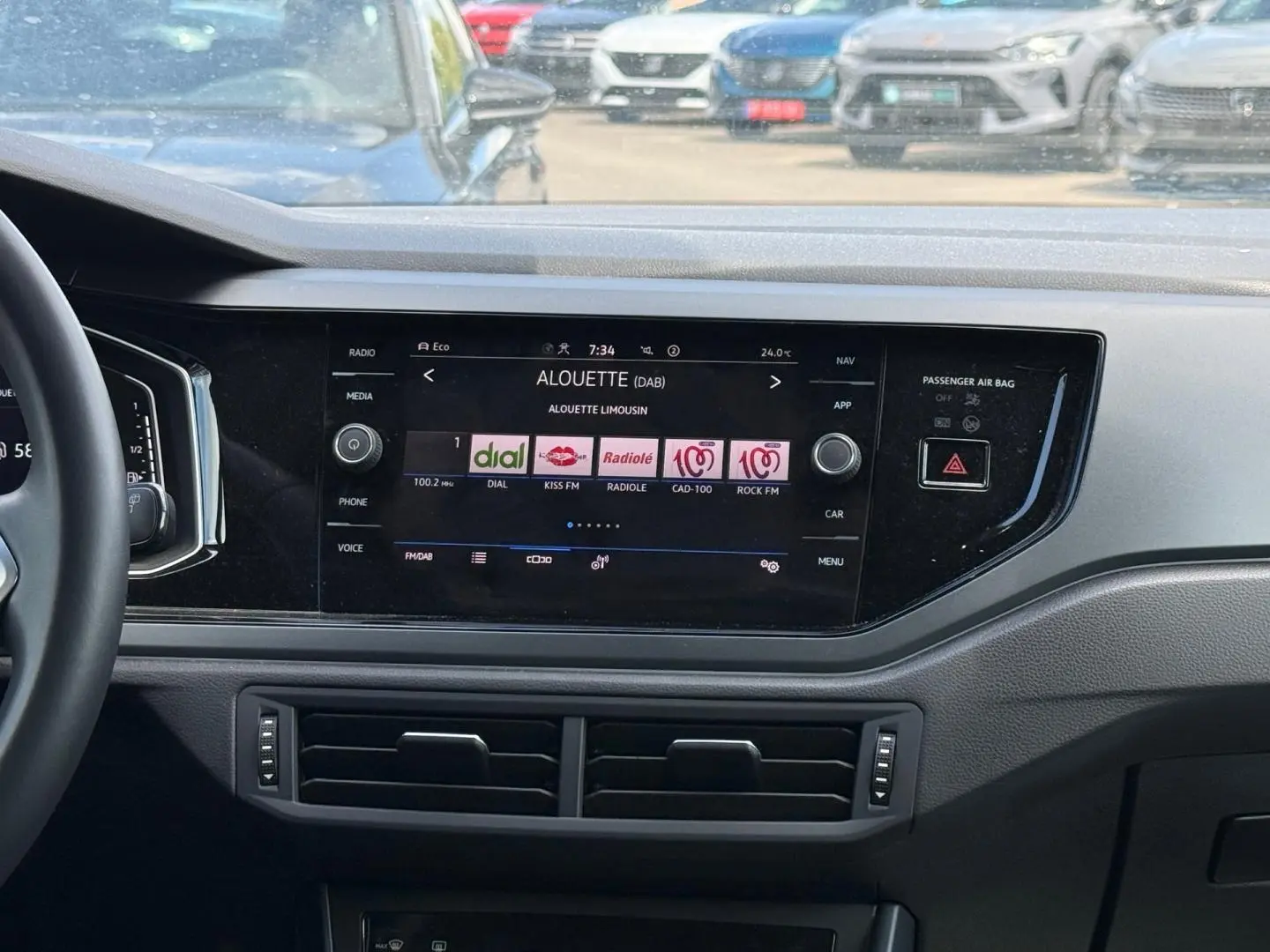 Vue intérieure du tableau de bord du Volkswagen Taigo gris 2025, avec écran tactile central affichant les radios DAB.