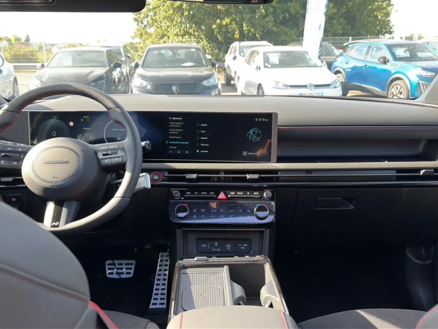 Vue intérieure avant du Hyundai Tucson 2026 gris shadow, tableau de bord moderne avec écran tactile large et volant cuir sport.