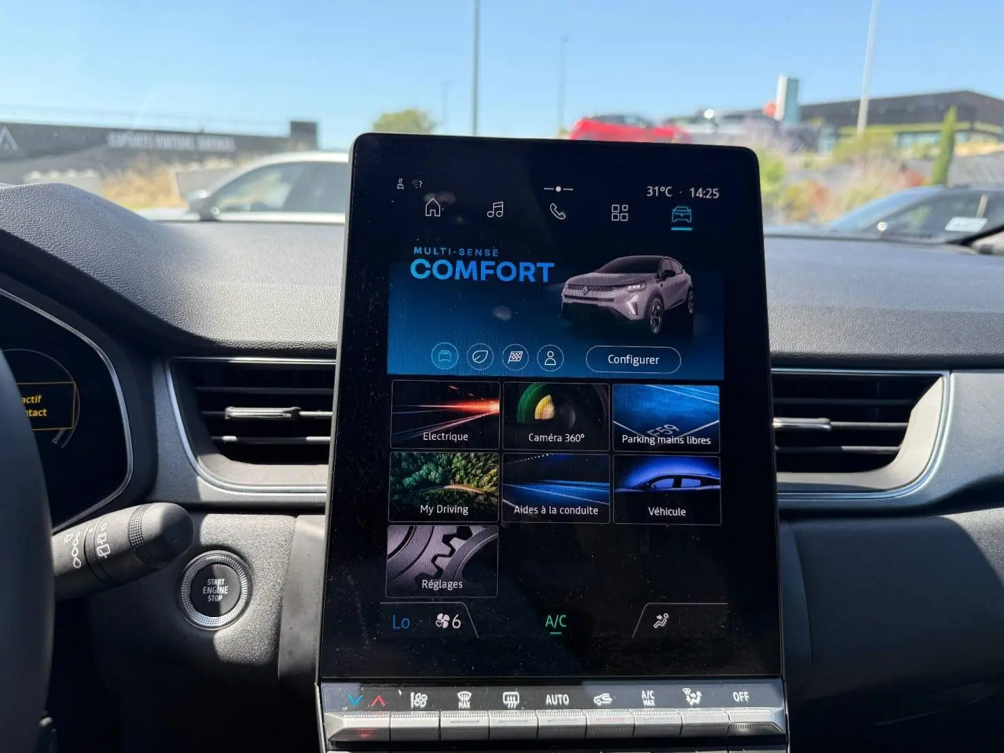 Vue intérieure centrée sur l'écran tactile vertical du tableau de bord du Renault Captur gris Rafale 2025.