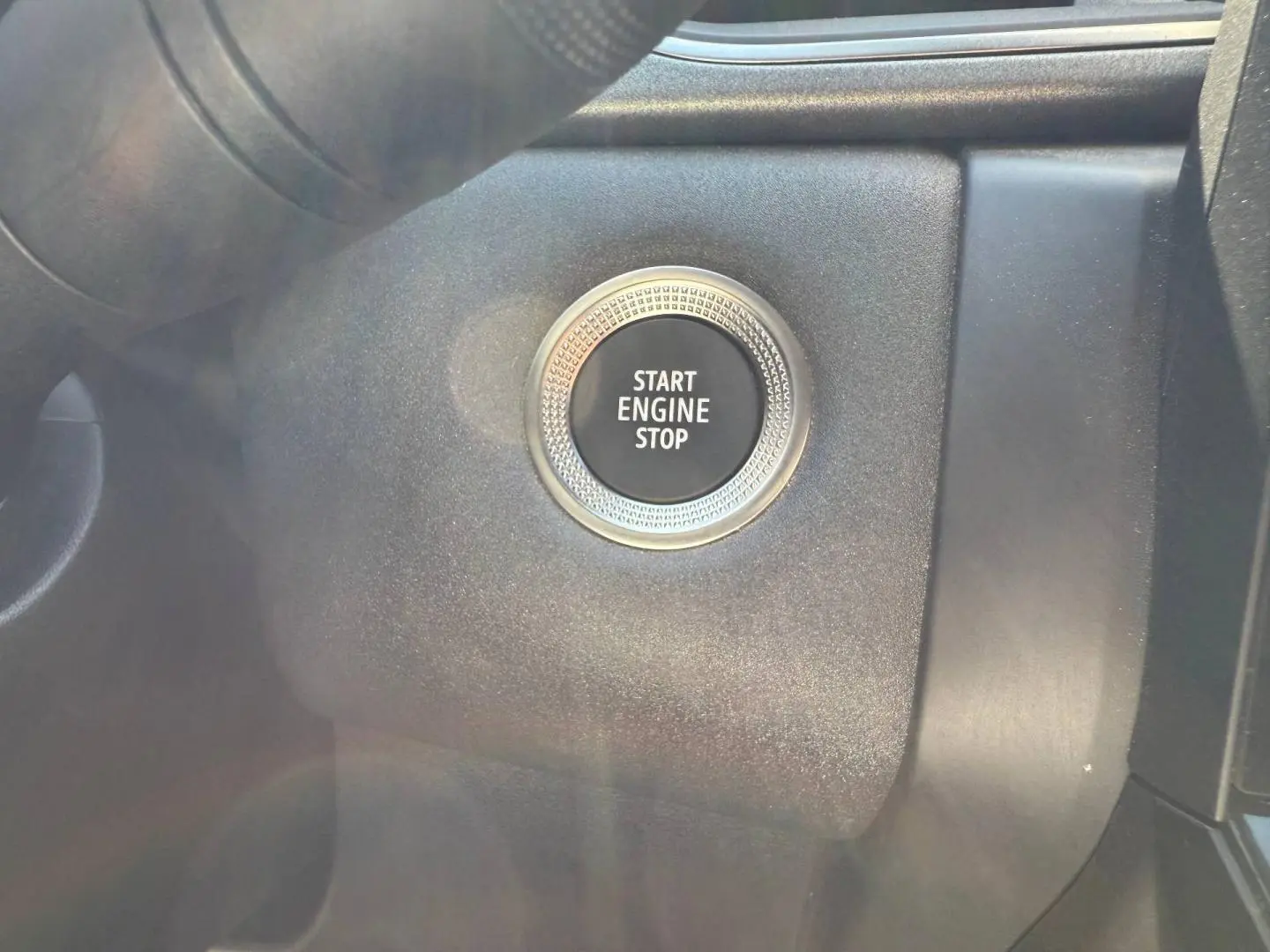 Gros plan sur le bouton Start Engine Stop noir entouré d'un anneau argenté dans l'habitacle du Renault Captur 2025.
