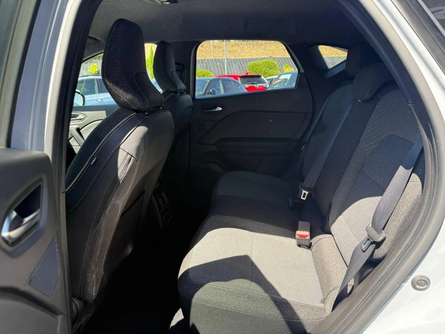 Vue intérieure côté droit des sièges arrière gris foncé du Renault Captur 2025 avec ceintures de sécurité visibles.