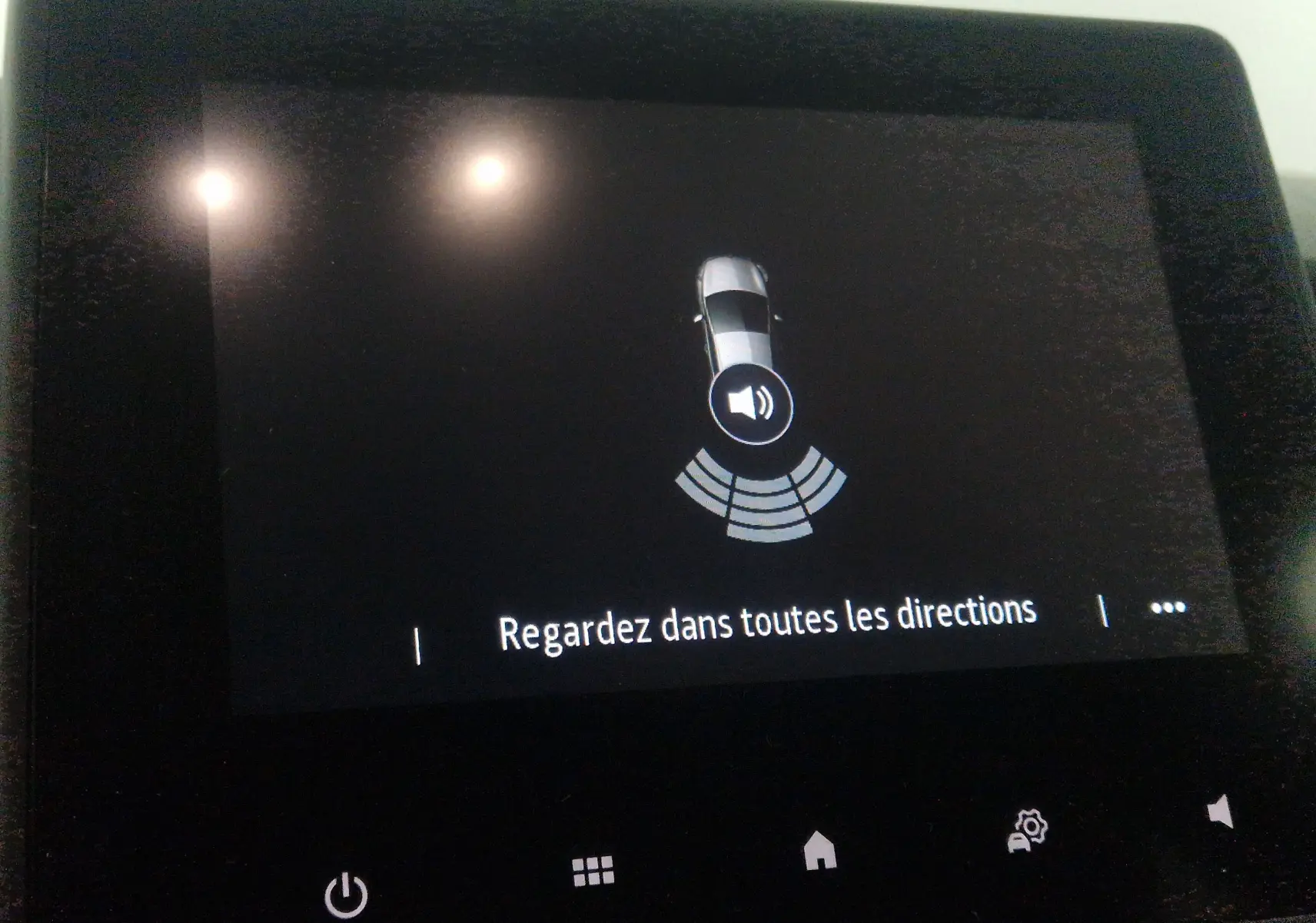 Écran central de Renault Clio V gris platine 2021 montrant l'alerte de détection d'obstacles avec message "Regardez dans toutes les directions"