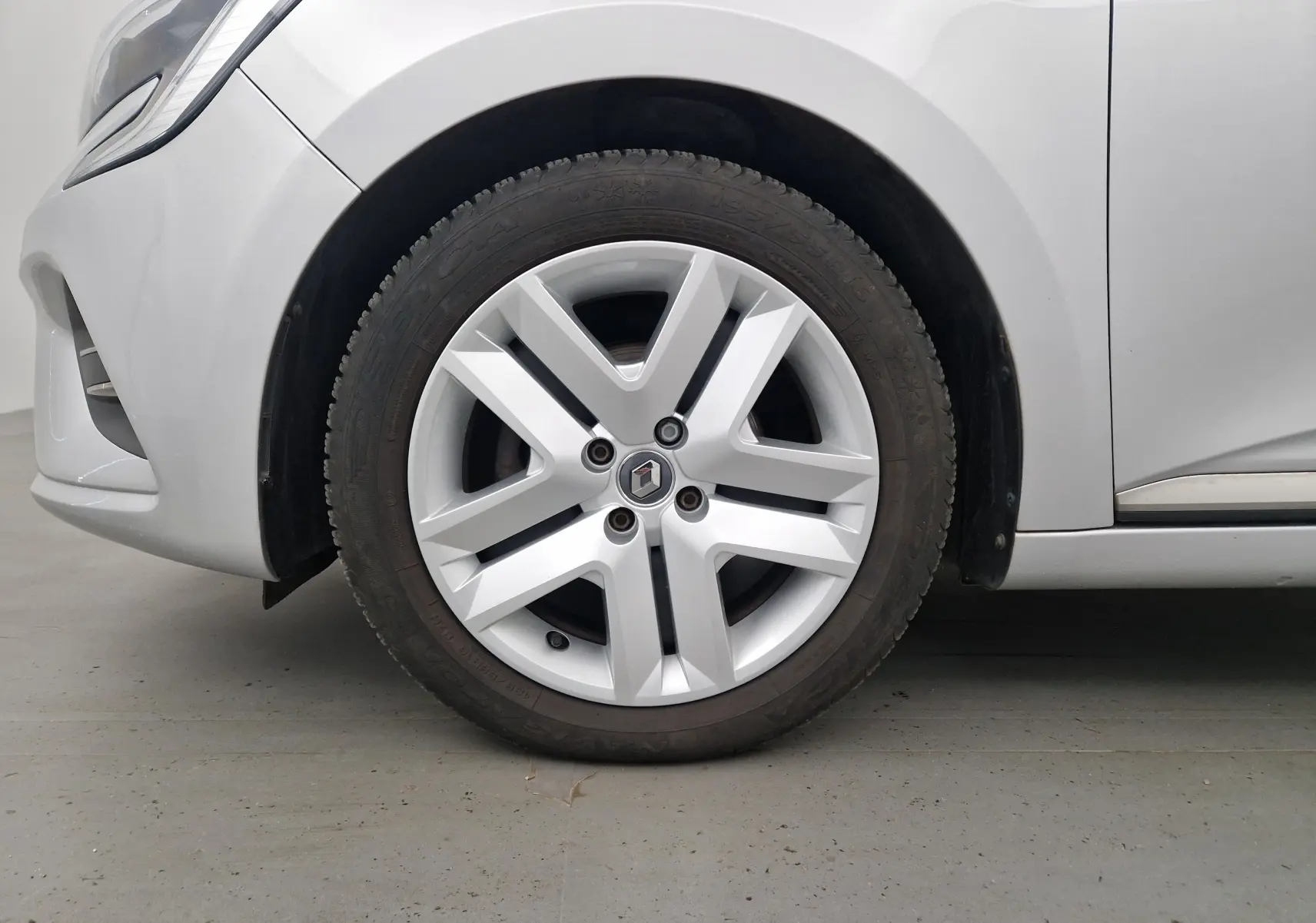 Gros plan sur la roue avant gauche gris platine d'une Renault Clio V 1.0 TCE 90 Zen avec jante alliage distinctive.