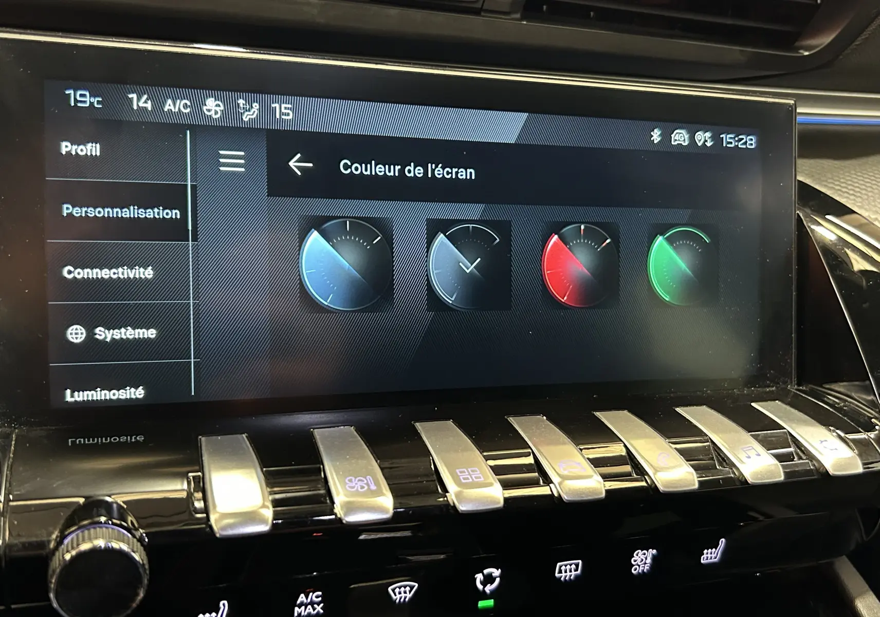 Écran tactile central de la Peugeot 508 SW 2024 affichant les options de couleur d'écran avec commandes piano en aluminium.