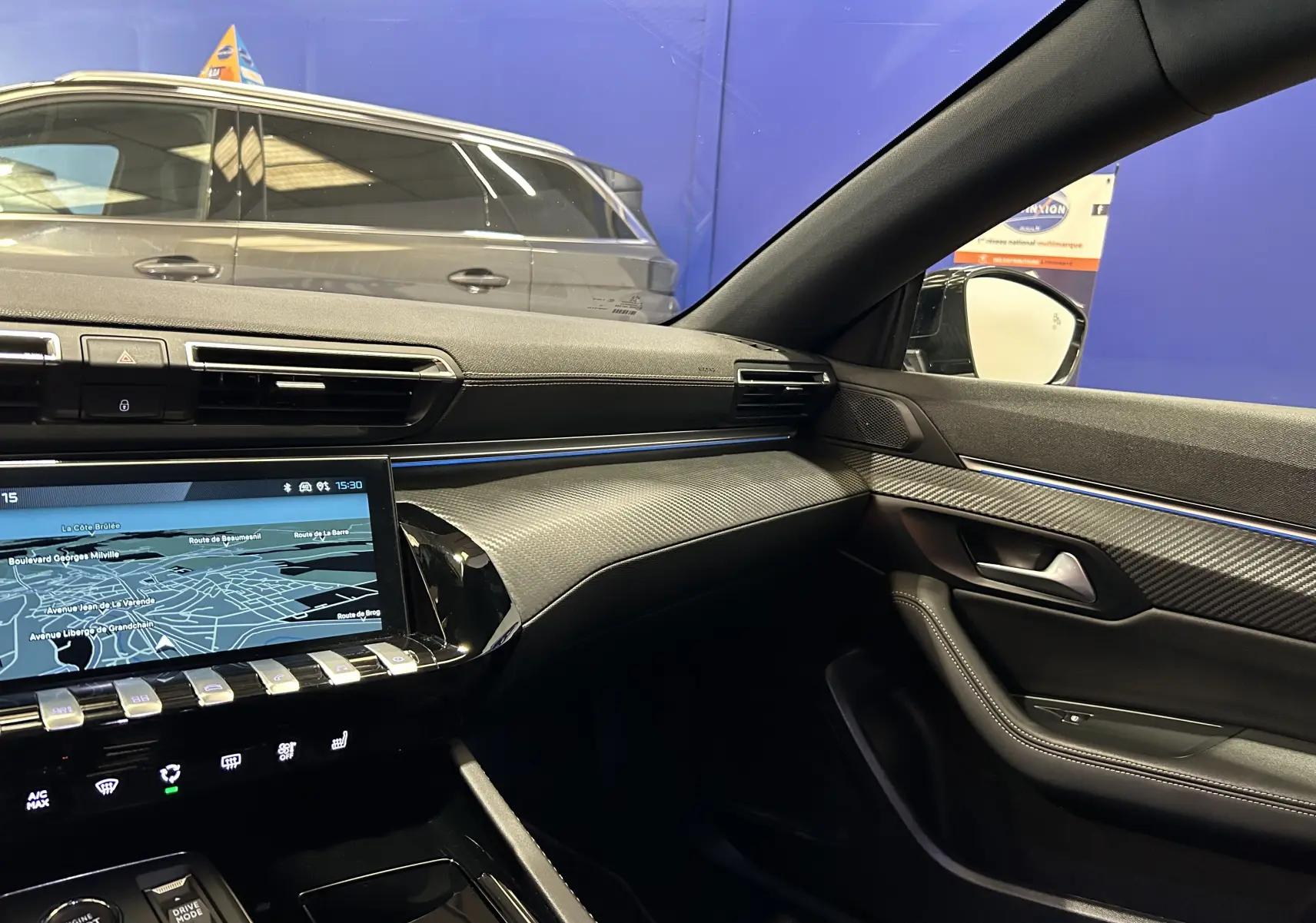 Intérieur côté passager du Peugeot 508 SW 2024 gris artense, avec tableau de bord moderne et écran tactile GPS allumé.