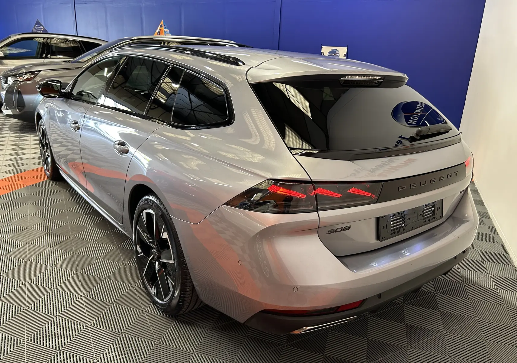 Peugeot 508 SW BlueHDi gris artense vue 3/4 arrière droit, feux LED et jantes alliage noires visibles.