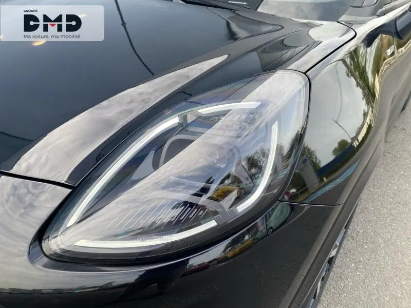 Gros plan sur le phare avant droit du Ford Puma noir Agate Métallisée, soulignant ses LED distinctives et la carrosserie brillante.