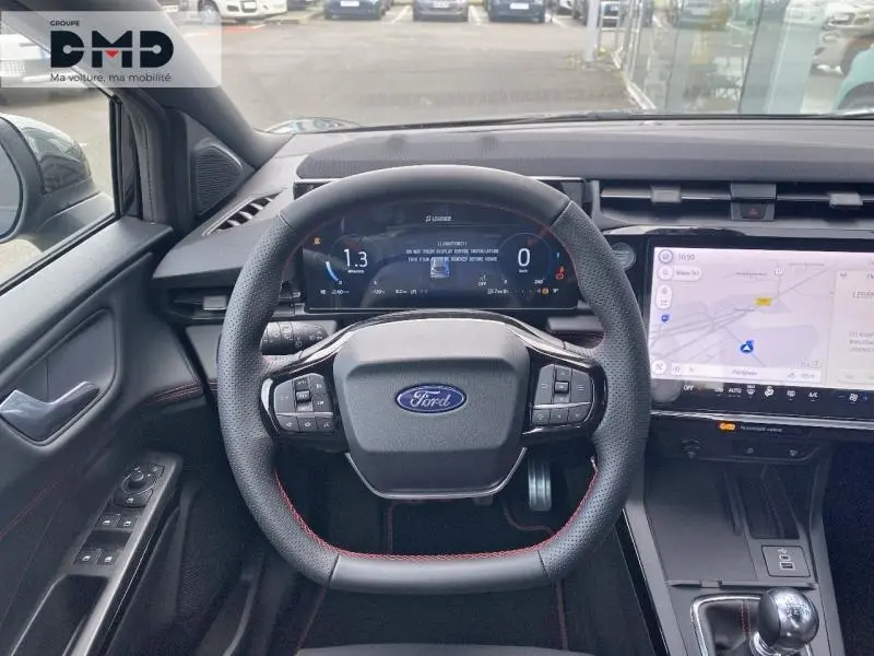 Vue intérieure centrée sur le volant multifonction noir avec surpiqûres rouges et tableau de bord numérique du Ford Puma 2026.