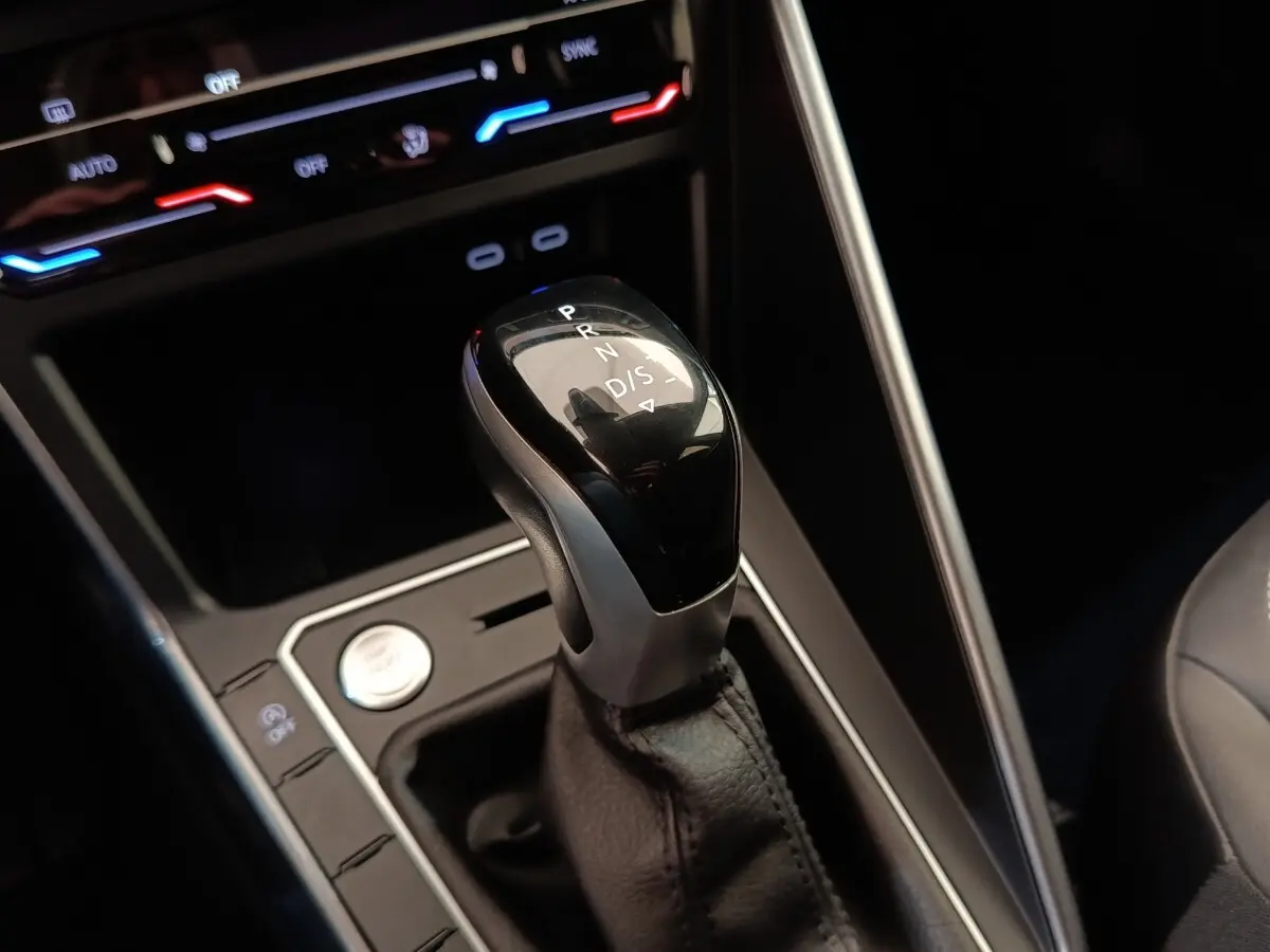 Le levier de vitesses automatique noir et argenté du Volkswagen Taigo 1.5 TSI 150 DSG Style, avec commandes et éclairage ambiant.