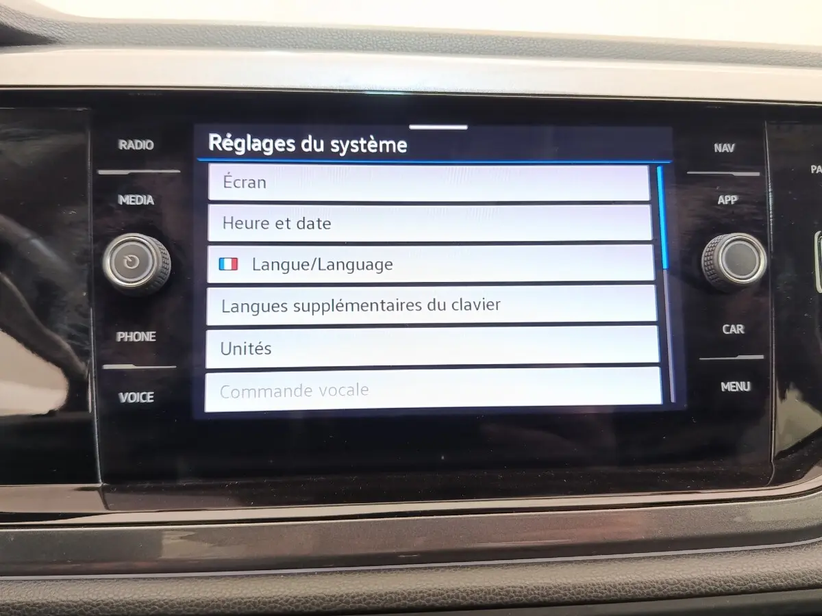 Écran tactile central du Volkswagen Taigo gris foncé, affichant les réglages du système en mode langue.