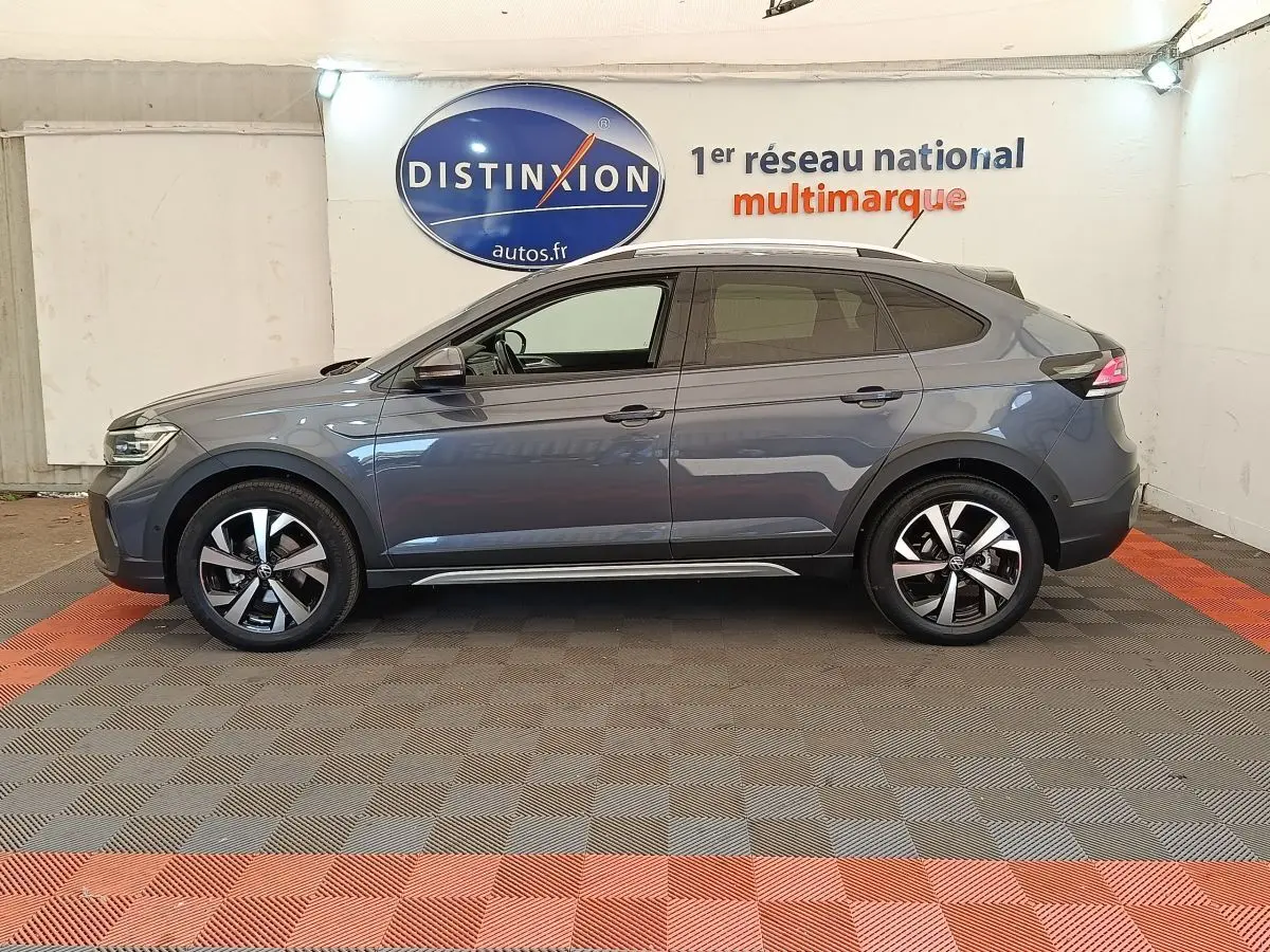 Vue latérale droite d’un Volkswagen Taigo gris foncé 2023, avec jantes alliage et toit panoramique visible.