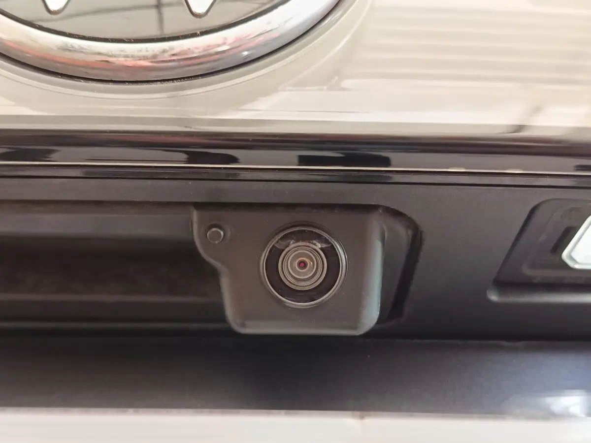 Gros plan sur la caméra de recul noire intégrée au hayon arrière du Volkswagen Taigo gris foncé 2023.